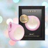 A pink LELO SILA Air Suction Clitoral Massager, made from extra-soft silicone and featuring a gold accent, is showcased alongside its black packaging. The packaging highlights a gold badge stating "Swedish Signature Design," surrounded by a gentle blur of blue and gray tones.